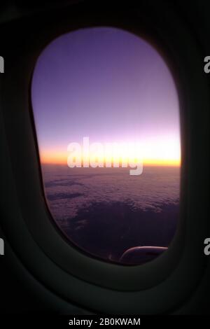 Sonnenuntergang durch ein Flugzeugfenster Stockfoto