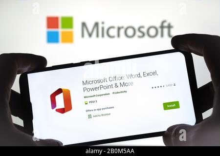 MS Office-App auf dem Smartphone in den Händen halten und Microsoft-Logo auf dem verschwommenen Hintergrund. Echtes Foto, keine Montage. Stockfoto