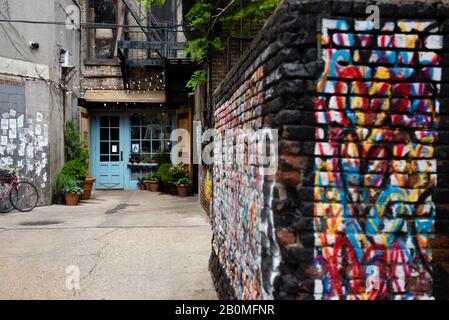 Ein Wandbild der Herzen wird auf eine Ziegelwand in einer Gasse gemalt, die zum Freemans Restaurant auf der Lower East Side von New York City führt. Stockfoto