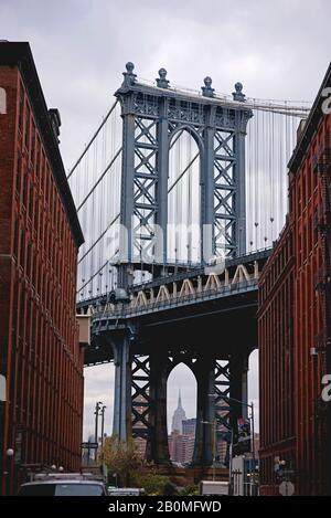 Blick auf das Empire State Building unterhalb der Manhattan Bridge von DUMBO, Brooklyn. Stockfoto