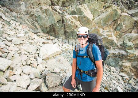 Portrait des Bergsteigers mit Helm und Rucksack. Stockfoto