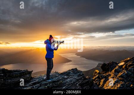 Figur mit Kamera über Queenstown und Lake, Remarkables New Zeala Stockfoto