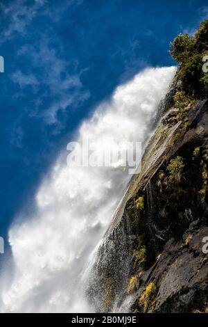 Wasserfall Kaskadierung über Felsen in einer üppigen grünen Landschaft und blauen Himmel Stockfoto