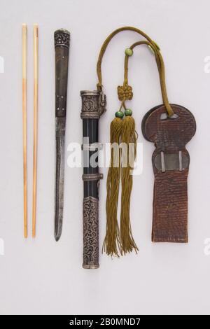 Messer mit Ummantelung, Essstäbchen und Gürtelschlaufe, Chinesisch, Mandschurei oder mongolisch, ca. 1750-1900, Chinesisch, Mandschurei oder mongolisch, Stahl, Holz, Ebenholz, Elfenbein, Silber, Messing, Leder, Koralle, Messer (A); L. mit Mantel 11 3/4 Zoll. (29,8 cm); L. ohne Ummantelung 10 1/8 Zoll (25,7 cm); W. 3/4 Zoll (1,9 cm); Wt. 2,2 oz. (62,4 g); Ummantelung (b); Wt. 7,7 oz. (218,3 g); Essstäbchen (c, d); L. 10 1/4 Zoll (26 cm); W. 3/16 Zoll (0,5 cm); Wt. 0,3 oz. (8,5 g), Messer Stockfoto