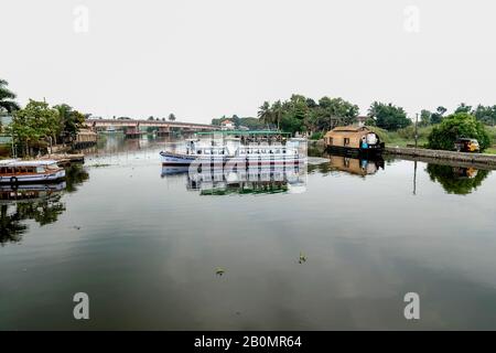 Ausflugsboot in Alleppey (Alappuzha), Kumarakom, Kerala, Indien. Geschossen vor dem Hintergrund von Kokospalmen und blauem Rückwasser, Venedig des Ostens. Stockfoto