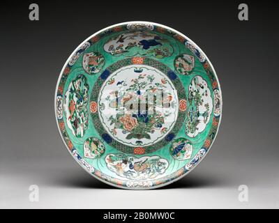 Platte mit Korb mit Verheißungsvollen Blumen, China, Qing-Dynastie (1644-1911), Kangxi-Marke und Periode (1662-1722), Datum Ende des 17.-frühen 18. Jahrhunderts, China, Porzellan mit farbigen Emaillierungen bemalt über durchsichtiger Glasur (Jingdezhen Ware), H. 3 5/8 Zoll. (9,2 cm); Durchm. 22 1/8 Zoll (56,2 cm); Durchmesser von Fuß 13 Zoll (33 cm), Keramik Stockfoto