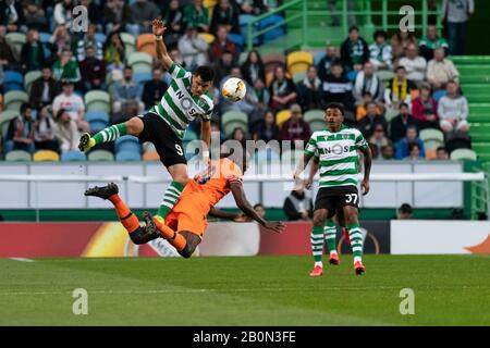 Der sportliche CP-Spieler Marcos Acuña (L) und der Istanbul Ba?ak?ehir FK-Spieler Demba Ba (C) werden während des UEFA Europa League-Spiels 2019/20 im Einsatz gesehen, Sporting CP vs Istanbul Ba?ak?ehir FK im José Alvalade Stadium.(Endstand: Sporting CP 3 -1 Istanbul Ba?ak?ehir FK) Stockfoto