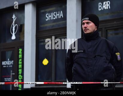 Hanau, Deutschland. Februar 2020. Ein Polizist steht Wache vor dem Ort einer der Zwillingsshootings in Hanau, 20. Februar 2020. Der mutmaßliche Schütze, der am späten Mittwoch in der westdeutschen Stadt Hanau neun Menschen bei Zwillingserschießungen erschoss und tötete, hatte ein "fremdenfeindliches Motiv", sagten Polizei und Beamte am Donnerstag. Credit: Lu Yang/Xinhua/Alamy Live News Stockfoto