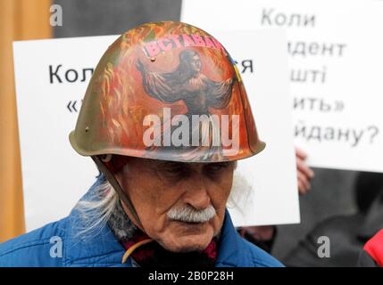 Kiew, Ukraine. Februar 2020. Ein Mann, der einen Maidan-Helm trägt, nimmt an einem Protest von Verwandten, Freunden und Anwälten der gefallenen Maidan-Aktivisten Teil, mit der Forderung, im Fall von Maidan zu ermitteln und für die, die sich schuldig gemacht haben, Maidan-Aktivisten oder "Helden des Himmlischen" 2014 zu töten. Außerhalb des Präsidiums im Zentrum von Kiew.Ukrainers jährt sich der 6. Jahrestag der Maidan-Revolution oder der Euromaidan-Revolution, bei der mindestens 100 Demonstranten getötet wurden. Credit: Sopa Images Limited/Alamy Live News Stockfoto