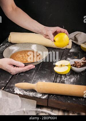 Die Hände der Frauen bereiten die Füllung von Apfel-Zimt-Brötchen vor. Nahaufnahme. Schritt-für-Schritt-Rezeptur Stockfoto