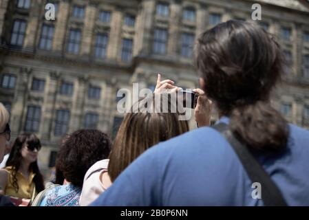 Zahlreiche Touristen besuchen den Dam Platz im Stadtzentrum von Amsterdam Stockfoto