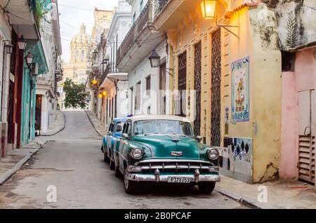 Am frühen Morgen in Den Straßen Von Havanna. Auf der linken Seite sind zwei klassische Autos zu sehen, in der Ferne Das Museum der Revolution Stockfoto