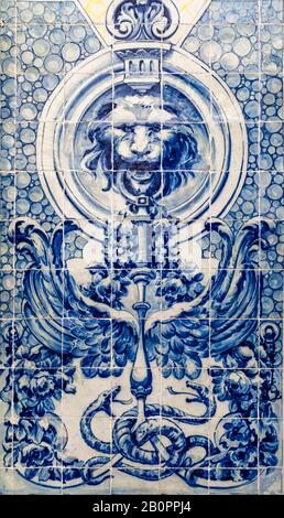 Portugiesische Traditionskacheln Azulejos bilden blaues Mosaik auf weißem Grund, das den Löwen darstellt, der einen Standfuß mit zwei Schlangen, Flügeln und Blumen hält Stockfoto