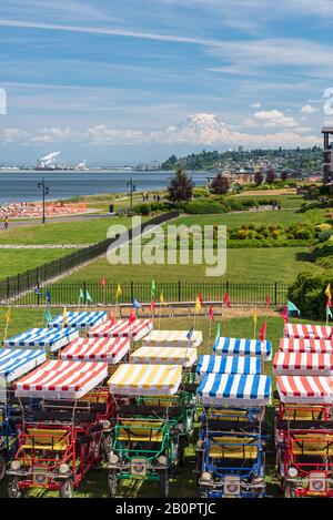 Mt Rainier schwebt über Downtown Tacoma und Beginn der Bucht von Punkt Ruston mit Menschen zu Fuß und Fahrrad Stockfoto