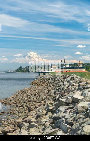 Mt Rainier schwebt über Downtown Tacoma und Beginn der Bucht von Punkt Ruston mit Menschen zu Fuß und Fahrrad Stockfoto