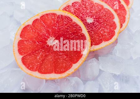 Grapefruitscheiben liegen auf Eiswürfeln. Nahaufnahme. Stockfoto