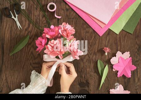 Frau, die Papier bouquet Holz Tisch mit Farbe, Papier, Schere für Valentines, Urlaub. Flatlay, Ansicht von oben. Stockfoto