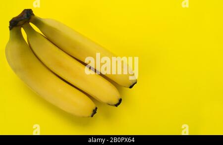 Drei Bananen auf gelbem Grund. Kopierbereich. Stockfoto