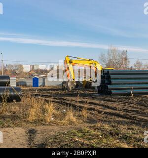 Gruppe von Baggern, die auf der Baustelle arbeiten, Verlegung von Engineering- und Heizsystemen. Russland, Omsk, 28.10.2019. Stockfoto