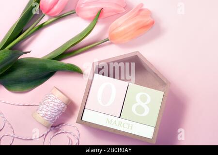 8. März Happy Women's Day Konzept. Mit Holzblockkalender und rosafarbenen Tulpen Stockfoto