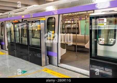 Der U-Bahn-Zug hält an einem Bahnhof und öffnet die Tür, um zu warten, bis Passagiere während der Hauptverkehrszeit an der U-Bahn-Station Kolkata East West einsteigen Stockfoto