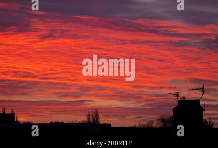 Wimbledon, London, Großbritannien. Februar 2020. Vor Sonnenaufgang im Südwesten Londons schimmelten Dächer vor einem leuchtend roten Himmel. Kredit: Malcolm Park/Alamy Live News. Stockfoto