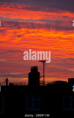 Wimbledon, London, Großbritannien. Februar 2020. Vor Sonnenaufgang im Südwesten Londons schimmelten Dächer vor einem leuchtend roten Himmel. Kredit: Malcolm Park/Alamy Live News.