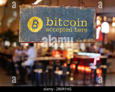 Hier hängend vor der Tür des Restaurants wurde ein Bitcoin akzeptiert. Bitcoin, ein elektronisches Geldkonzept Stockfoto