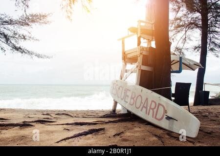 Leerer Rettungsschwimmer steht mit Rettungsbrett am Strand von Phuket, Thailand Stockfoto