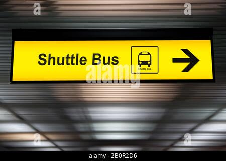 Schild mit Pfeilpunkt zum Shuttle-Busbahnhof am Flughafen für Passagiere, die vom Flughafen in die Stadt fahren möchten. Umsteigeverbindung für Stockfoto