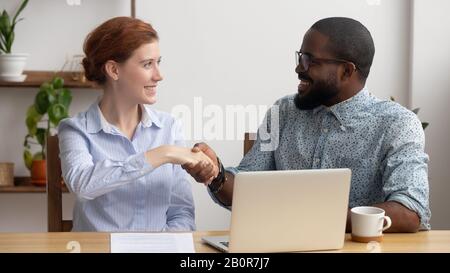 Glücklicher afroamerikanischer Manager schüttelt die Hand über Kunden, Begrüßung, Geschäftspartner, die einen finanziellen Deal machen, Händeschütteln nach erfolgreichen Verhandlungen, d. H Stockfoto