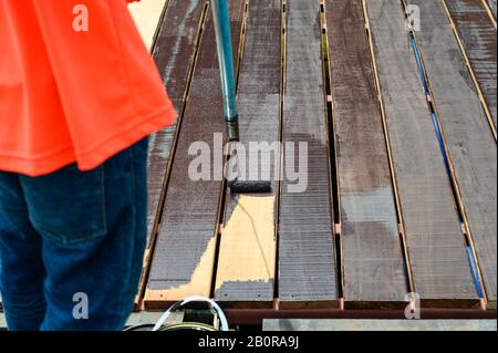 Lackiererei mit Lackierwalze auf Holzboden Stockfoto