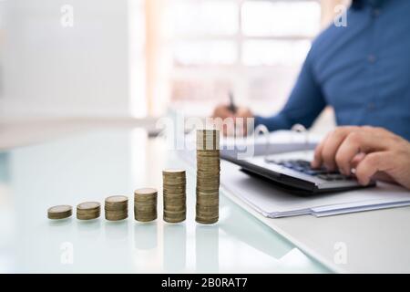 Mittelteil Der Geschäftsrechnung Mit Gestapelten Münzen, Die Am Office Desk Angeordnet Wurden Stockfoto