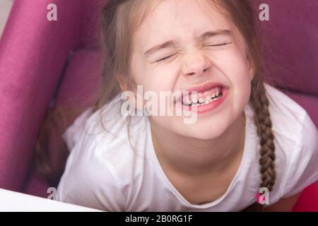 Kleine Mädchen zeigt ihre Zähne. Konzept der Babyzähne. Stockfoto