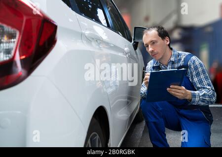 Insurance Agent Inspection White Car Paint Auf Kratzer Stockfoto