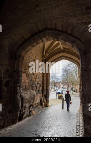 Warwick: Blick auf die West Street durch den mittelalterlichen (normannischen) West Gate Steinbogen mit gekleidtem Stein frühenglisches Gewölbedach. Stockfoto