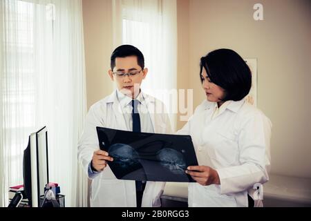 Nahaufnahme des Arztes, der Röntgenfilm des Patienten im Krankenhaus hält. Stockfoto