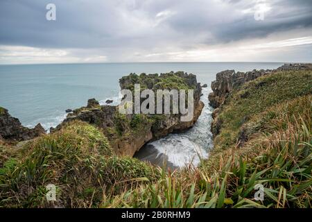 Bucht mit Sandsteinfelsen, Felsformation Pancake Rocks, Paparoa-Nationalpark, Punakaiki, Westküste, Südinsel, Neuseeland Stockfoto