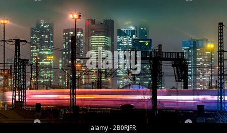 Am Abend fährt der Zug vor der Skyline, farbenfroh beleuchtet, Hauptbahnhof, Frankfurt, Hessen, Deutschland Stockfoto