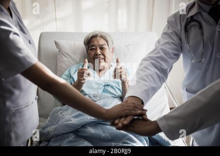 Die Nähe der Teamärzte verbindet sich, bevor sie mit der Pflicht und dem Patienten hinter ihnen erfolgreich sind. Stockfoto