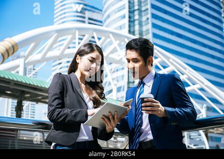 Die Kollegen im Unternehmen sehen sich die Arbeit im Tablet zusammen an. Stockfoto