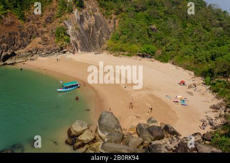 Blick auf die Menschen am schönen, sauberen und bovenförmigen Schmetterlingsstrand mit klarem blauem Wasser in Canacona, Goa, Indien. Stockfoto