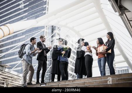 Asiatische Studenten werden von ihrem Elternteil bei der Abschlussfeier gratuliert Stockfoto