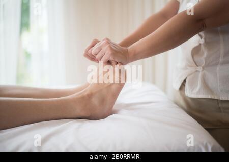 Schöne Frau mit Fußmassage im Schönheitssalon, Entspannung und Gesundheit. Stockfoto