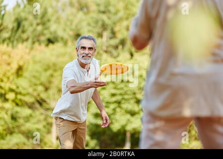 Glückliches Paar Senioren spielen im Sommer Frisbee Stockfoto