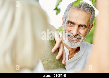 Der alte Mann flirtet im Sommer mit einer Frau in der Natur Stockfoto