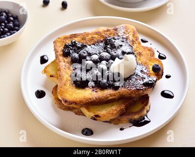 Nahaufnahme von französischem Toast mit Blaubeersauce auf weißem Teller. Stockfoto