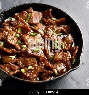 Nahaufnahme der in Sojasoße mit Gewürzen in asiatischem Stil gedämpften Fleischstücke. Mongolisches Rindfleisch. Stockfoto