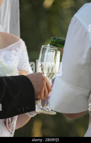 Champagner wird in Gläser für die Brautpaar gegossen Stockfoto