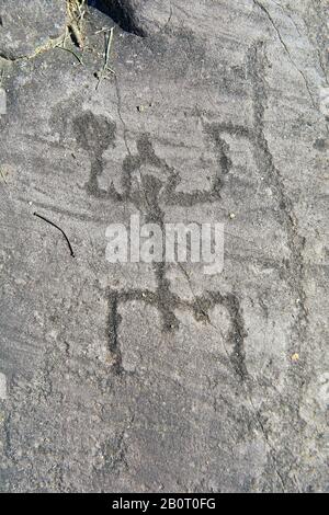 Petroglyph, Steinschnitzerei, einer schematischen menschlichen Figur in "Gebetstellung", die einen gekerbten Helm trägt. Von den alten Camuni-Leuten im Eisen geschnitzt Stockfoto